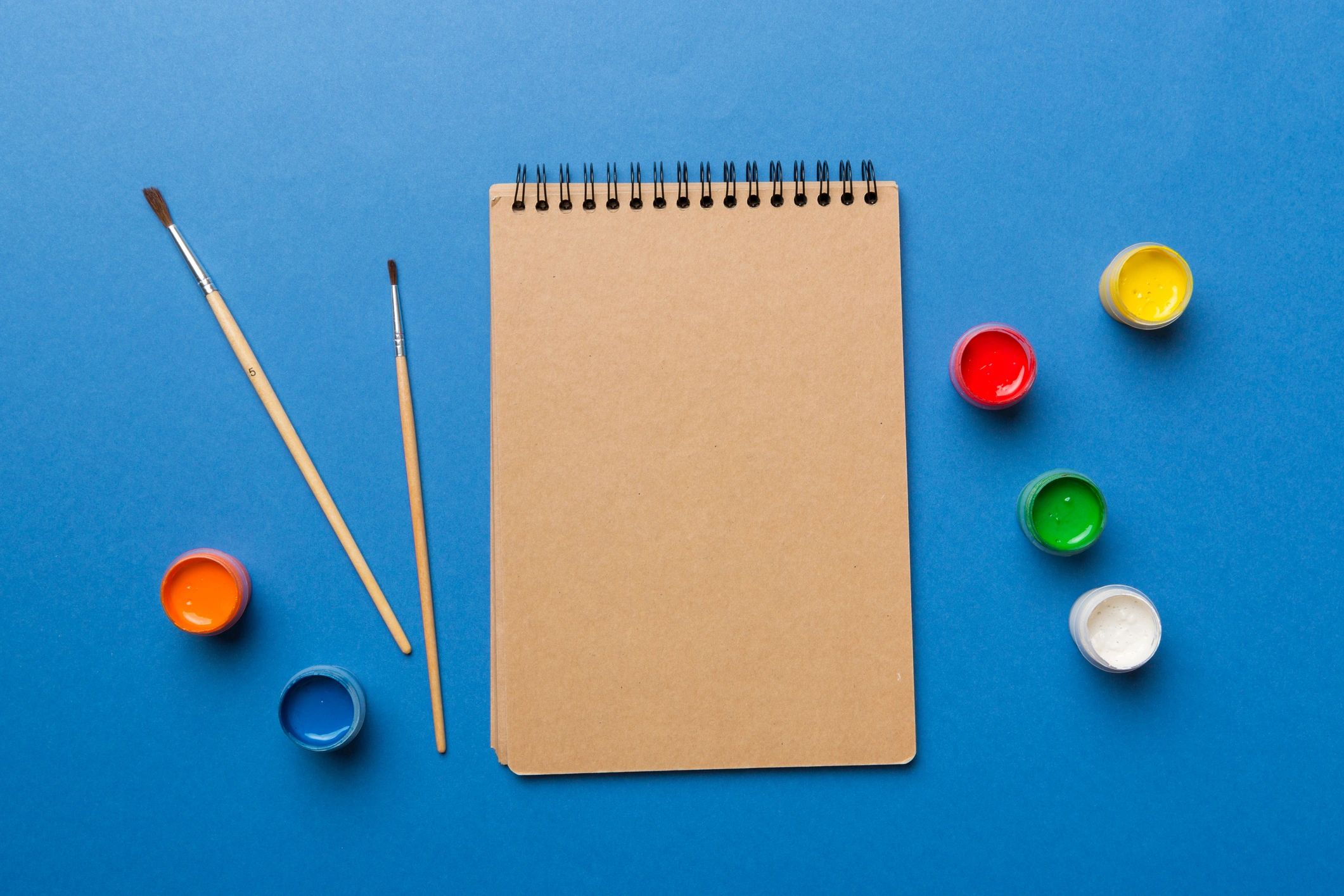 Flat lay of colouring supplies with sketchbook and pencils