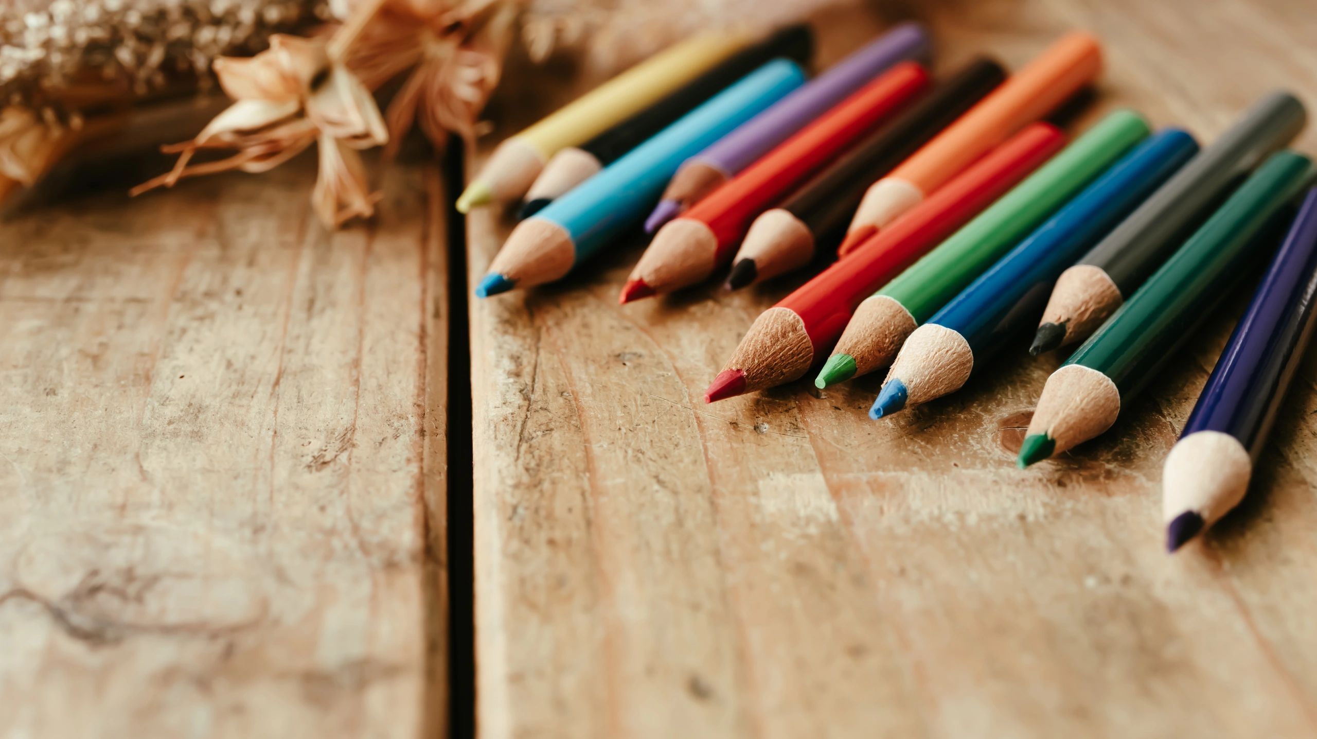 Coloured pencils on a wooden desk
